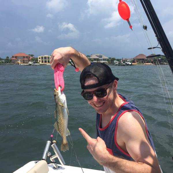 Man holding to speckled trout he caught
