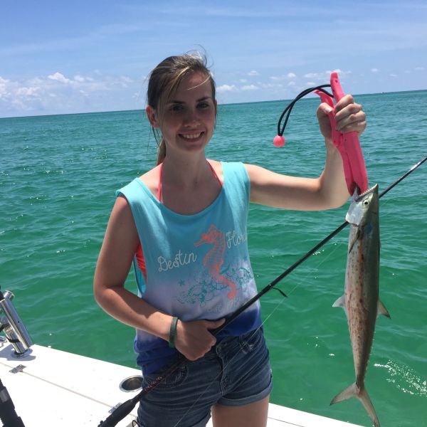 Girl holding up spanish mackerel she just caught
