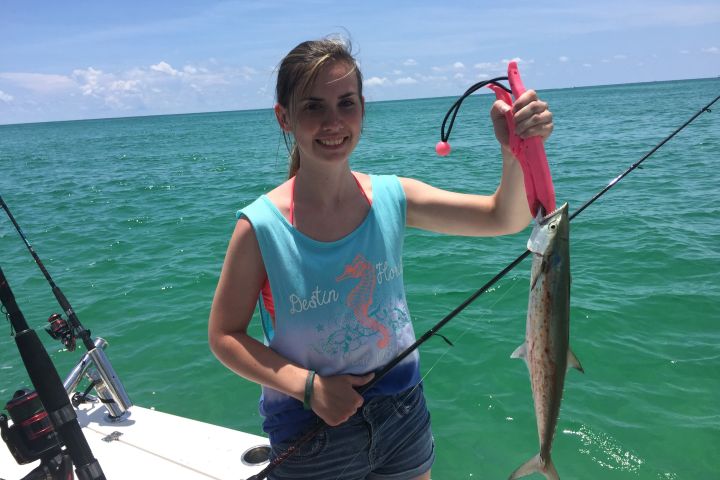 Girl holding up spanish mackerel she just caught