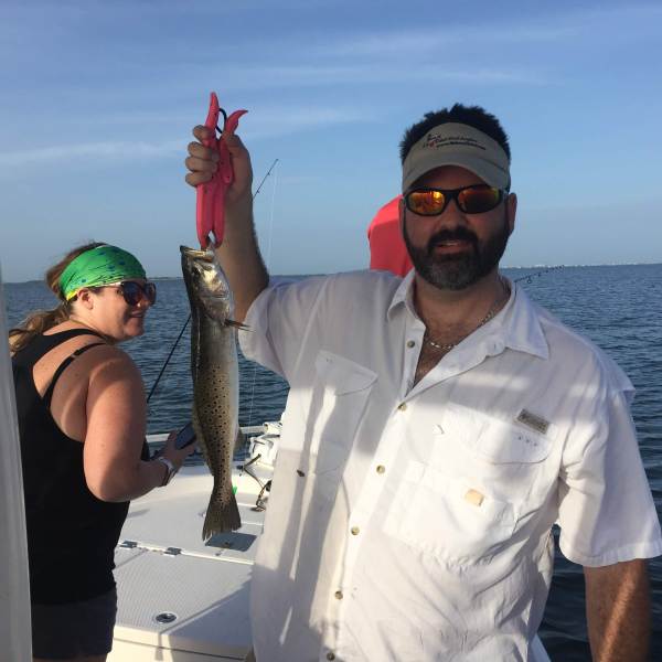 Man holding up fish on boat