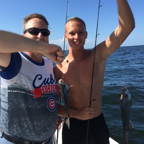 Man and boy holding up fish they caught