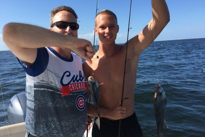 Man and boy holding up fish they caught