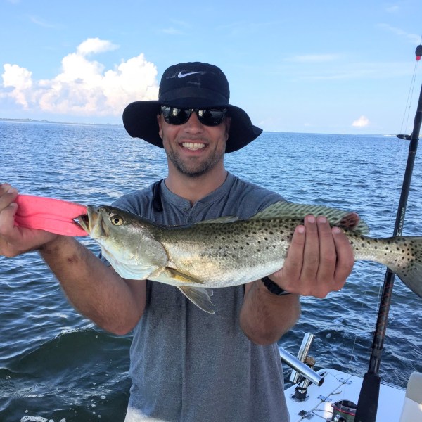 Man holding up fish caught on fishing charter