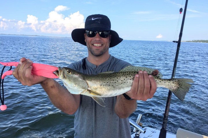 Man holding up fish caught on fishing charter