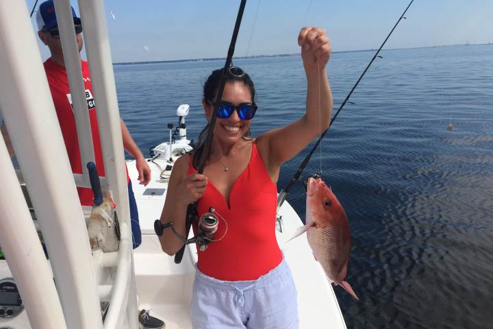 Woman holding up Redfish she caught