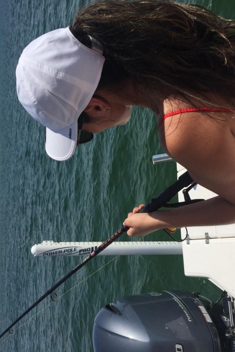 Woman fishing off back of the boat in Destin