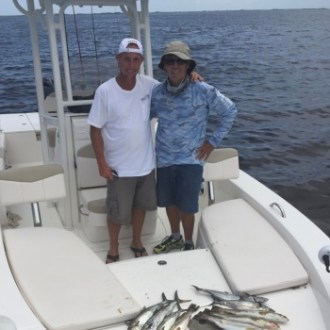 Two people smiling for photo onboard small boat